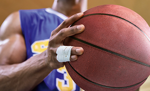 Immagine di una persona con Leukotape Classic che tiene in mano un pallone da basket